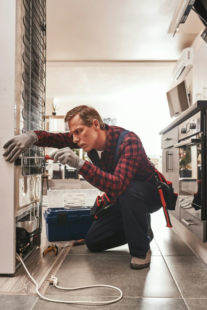 Should be attantive. Senior male technician checking refrigerator